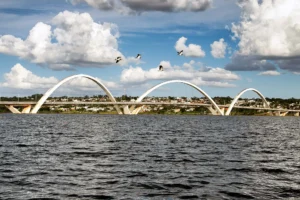 Vista da Ponte Juscelino Kubitschek sobre o Lago Paranoá em Brasília, destacando a arquitetura moderna e o cenário urbano.