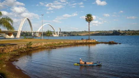 Pessoa praticando lazer no Lago Paranoá com ponte ao fundo no Lago Norte em Brasília.