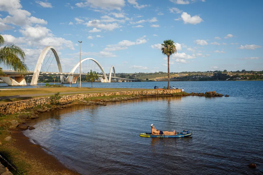 Pessoa praticando lazer no Lago Paranoá com ponte ao fundo no Lago Norte em Brasília.